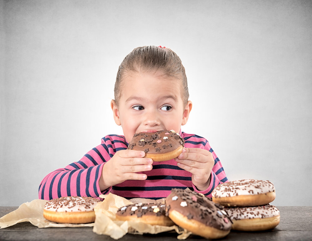 Child Eating Sweet Chocolate Donuts