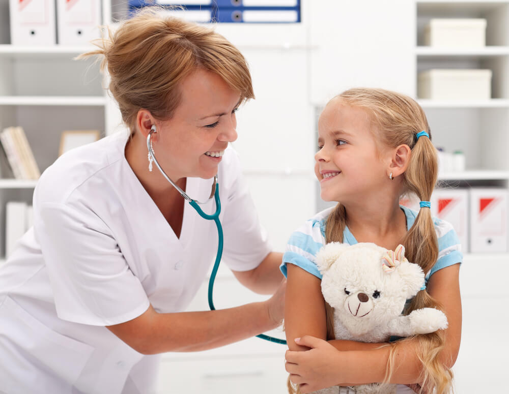 Happy Little Girl at the Doctor for a Checkup - Being Examined With a Stethoscope