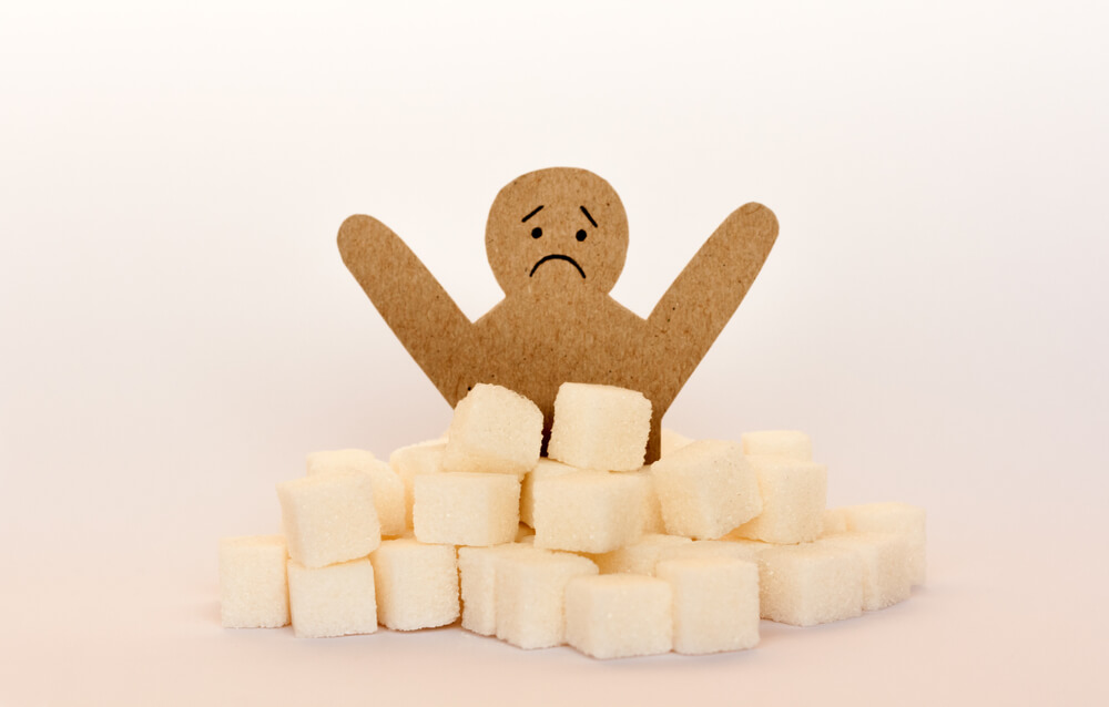 Sugar Addiction, Insulin Resistance, Unhealthy Diet, Figure of a Cardboard Man Surrounded by Refined Sugar Cubes on White Background