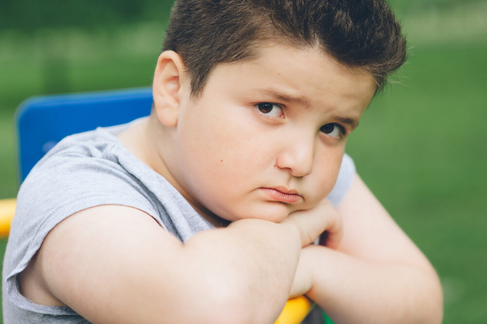 Sad Fat Boy Sitting on the Sports Simulator