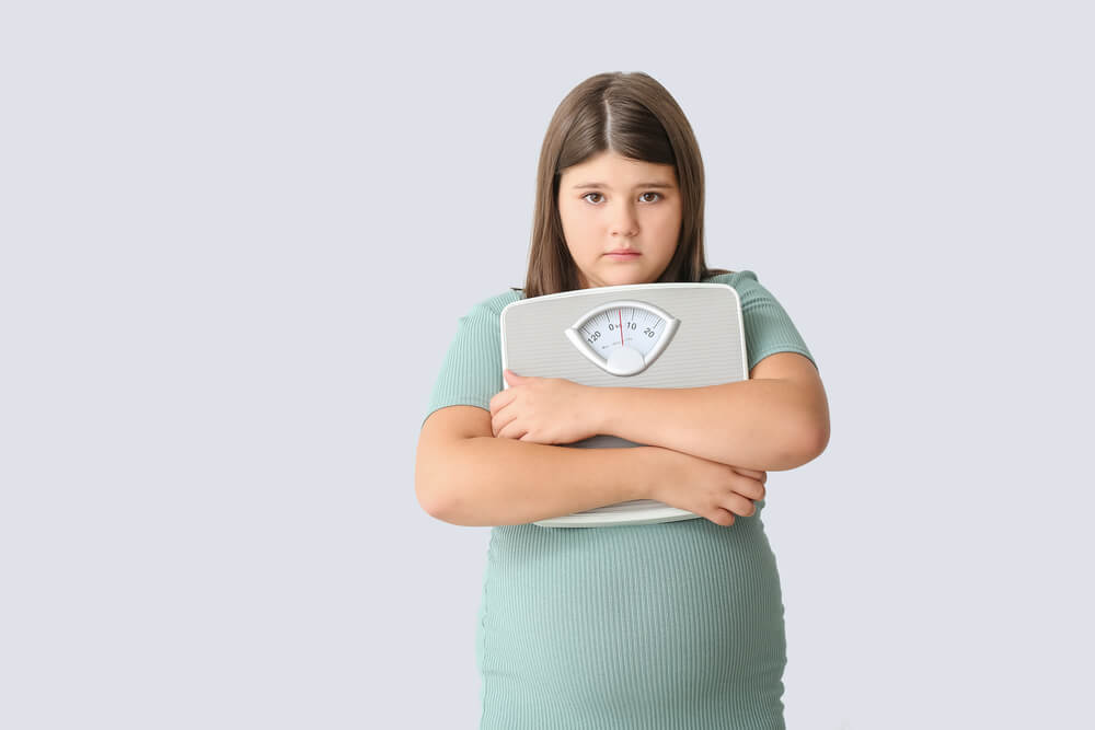 Sad Overweight Girl With Measuring Scales