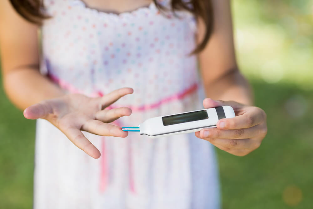Close-up of Girl Testing Diabetes on Glucose Meter in Park