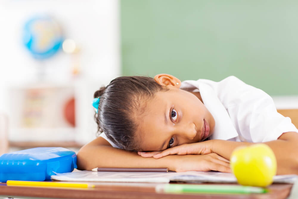 Primary Schoolgirl Resting On Des