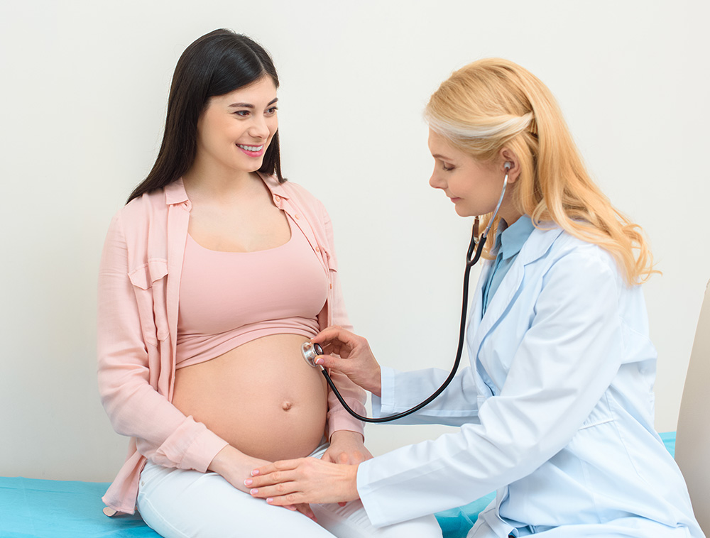 Beautiful Black Haired Pregnant Woman Being Examined by a Female Doctor