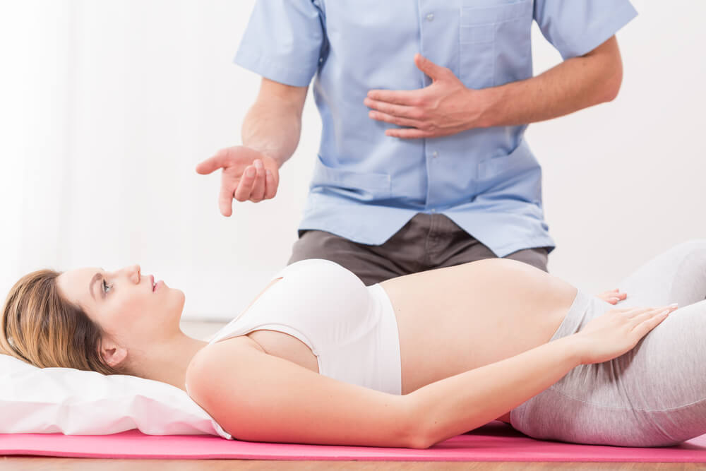 Pregnant Woman Lying and Doing Breathing Exercise at a ‏Lamaze Class