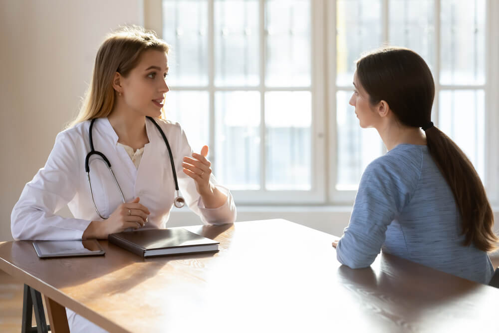 Young Female Doctor Talk Consult Patient at Meeting in Private Hospital