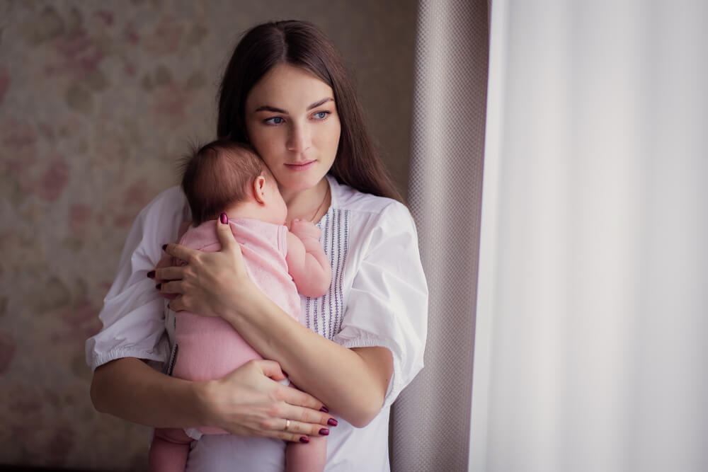 A Young Mother Rocks Her Kid and Sings a Lullaby at Home