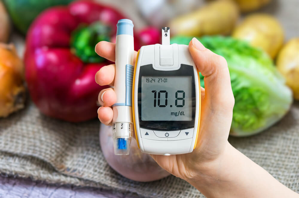 Diabetic Diet and Diabetes Concept. Hand Holds Glucometer