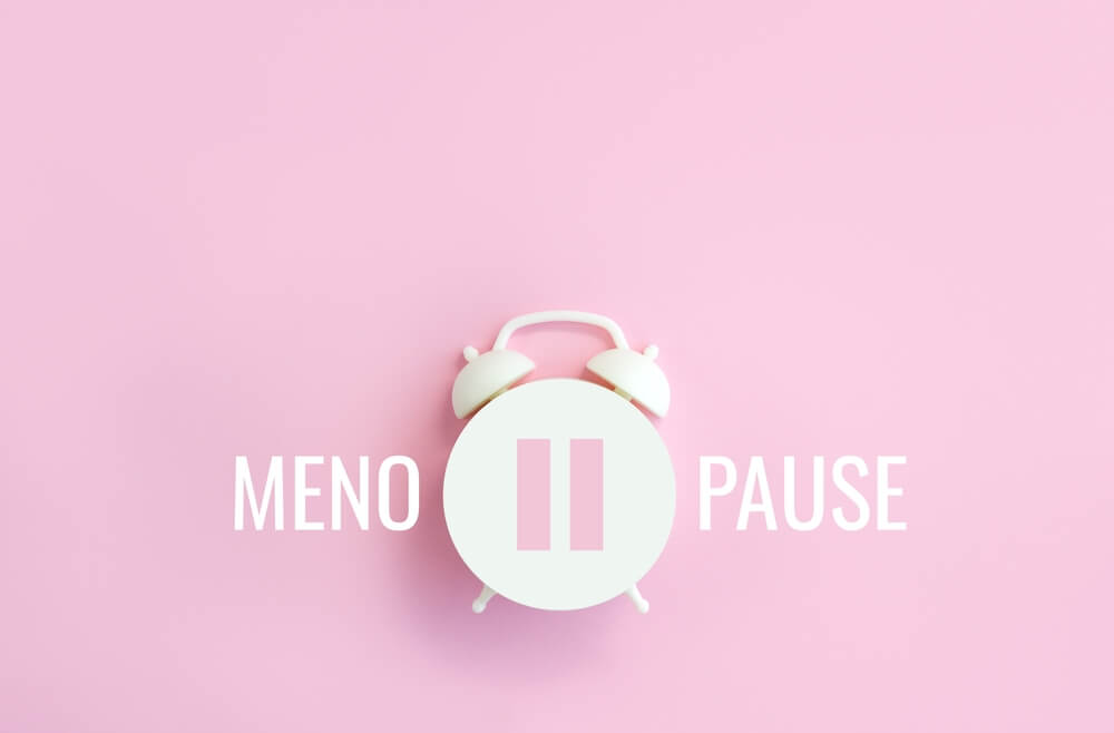 Word Menopause, Pause Sign on a White Alarm Clock on Pink Background. Minimal Concept Hormone Replacement Therapy