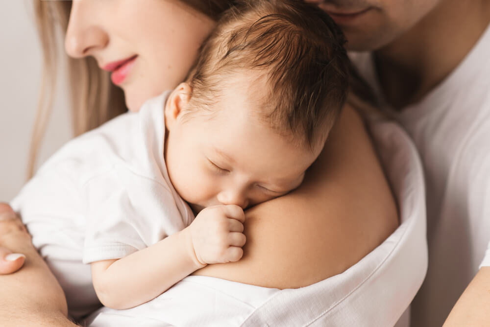 A Loving Mother Carries Her Newborn Baby at Home