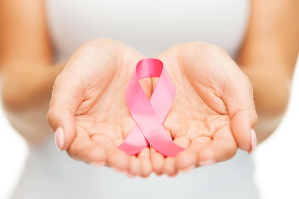 Healthcare and Medicine Concept - Woman’s Hands Holding Pink Breast Cancer Awareness Ribbon