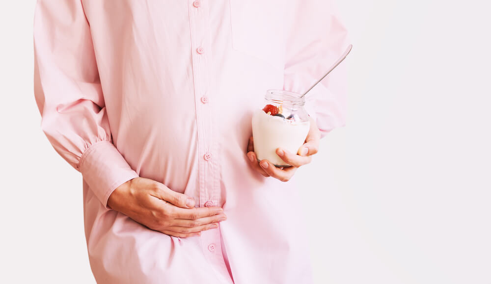Beautiful Pregnant Woman With Healthy Snack of Yogurt With Granola and Fruits