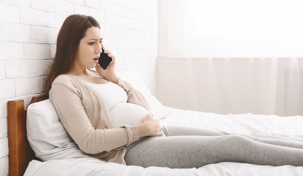 Young Pregnant Woman Feeling Some Pain and Discomfort at Home and Calling Her Doctor, Panorama, Free Space