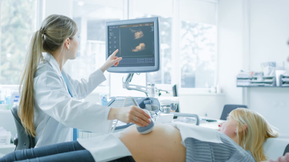 In the Hospital, Obstetrician Uses Transducer for Ultrasound