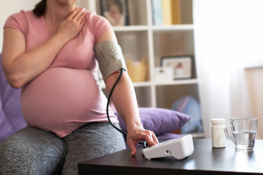A Woman Measures Blood Pressure With an Electronic Pressure Gauge, Headache During Pregnancy