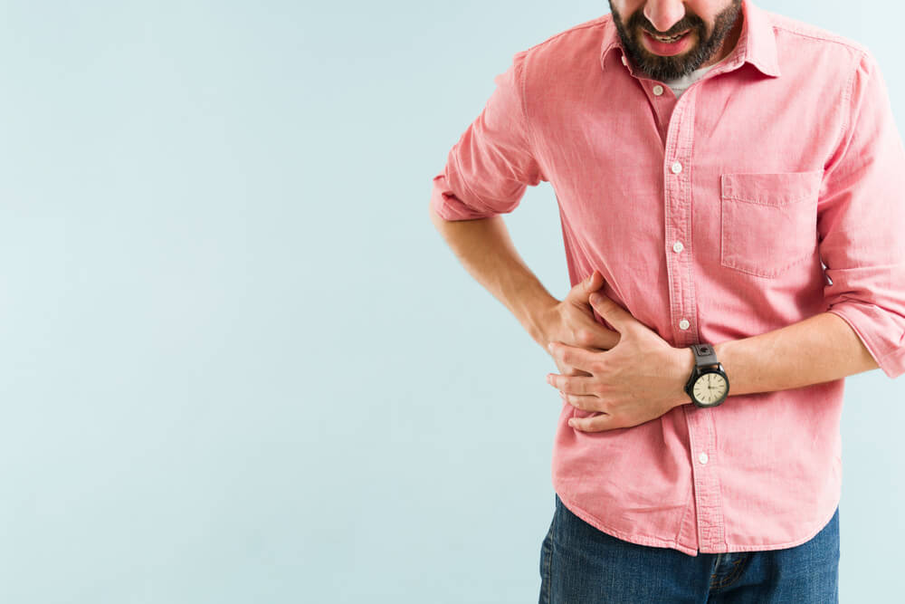 Close Up Of A Stressed Man In His 30s Suffering From A Gallbladder Sickness.