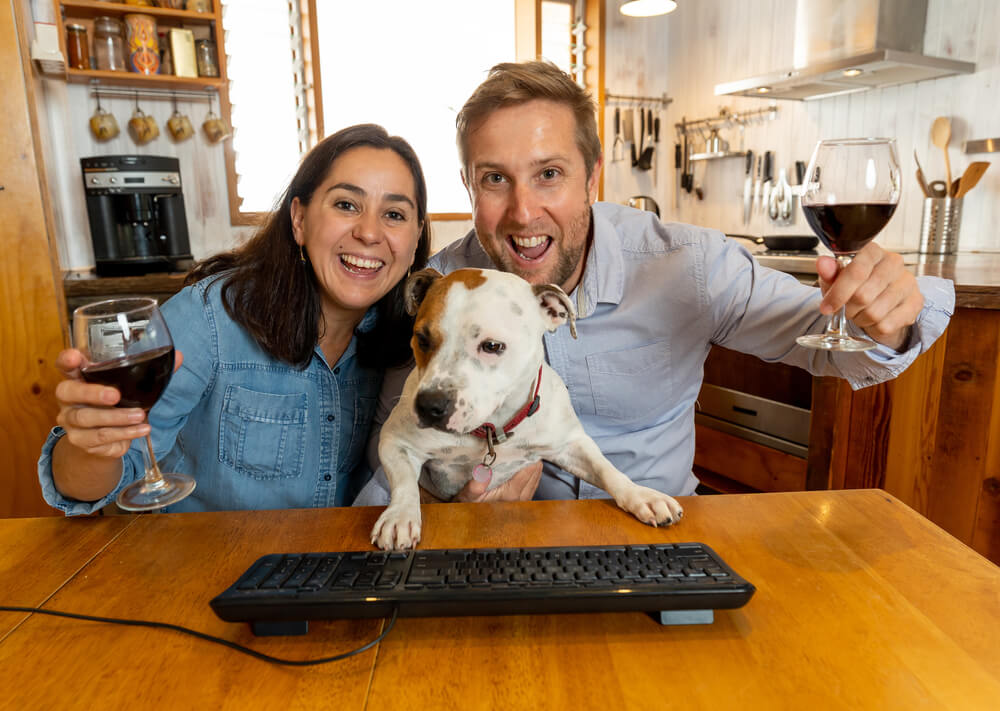 Screen View of Happy Couple and Pet Dog Video Calling Friends Using Laptop at Home. 