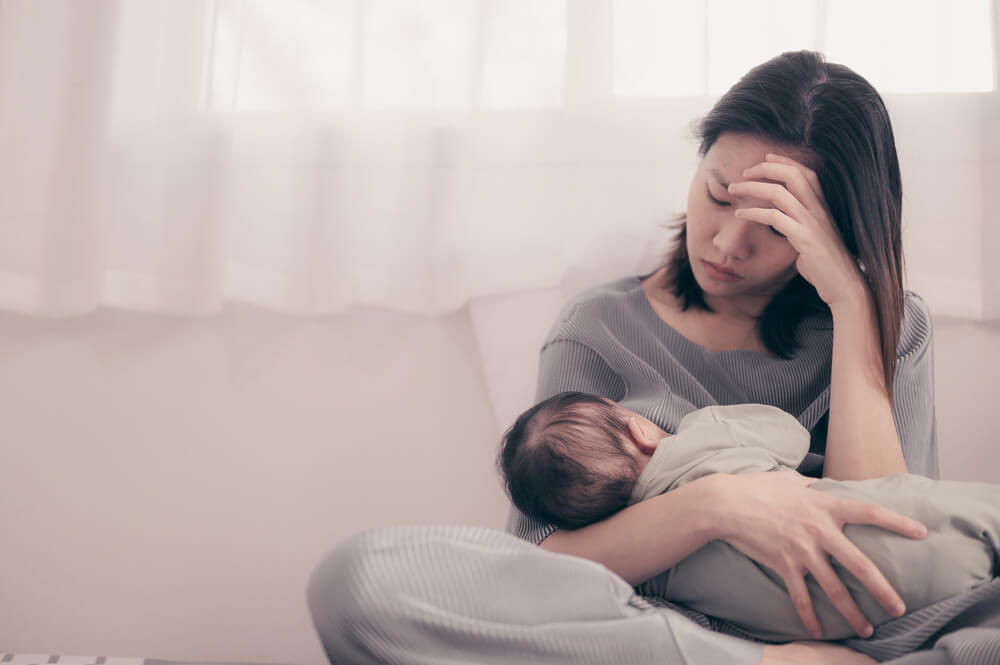 Tired Mother Suffering From Experiencing Postnatal Depression.