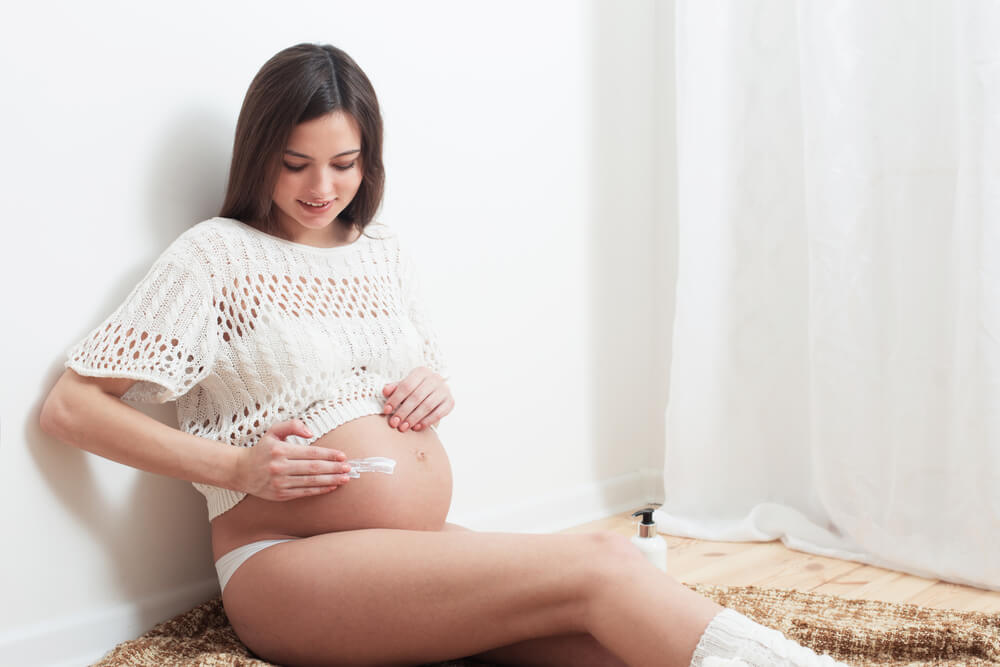 Pregnant Woman Putting Cream on Her Belly to Avoid Stretch Marks