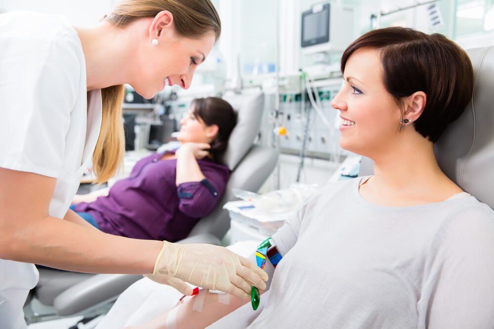 Nurse in Drop-in Department or Clinic Taking Blood From Woman Donor