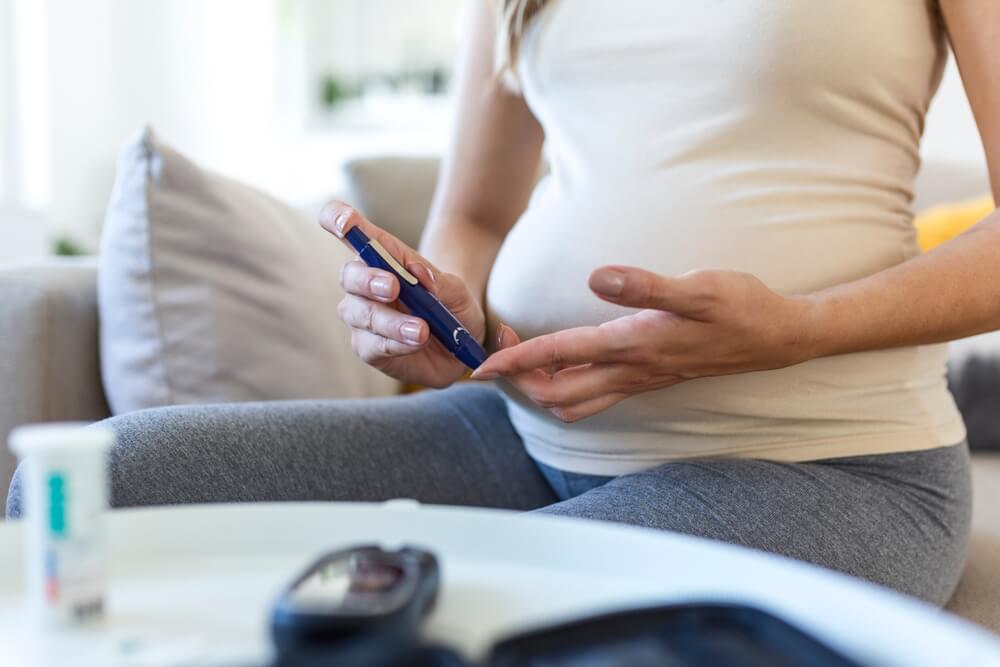 Pregnant Woman Checking Blood Sugar Level at Home