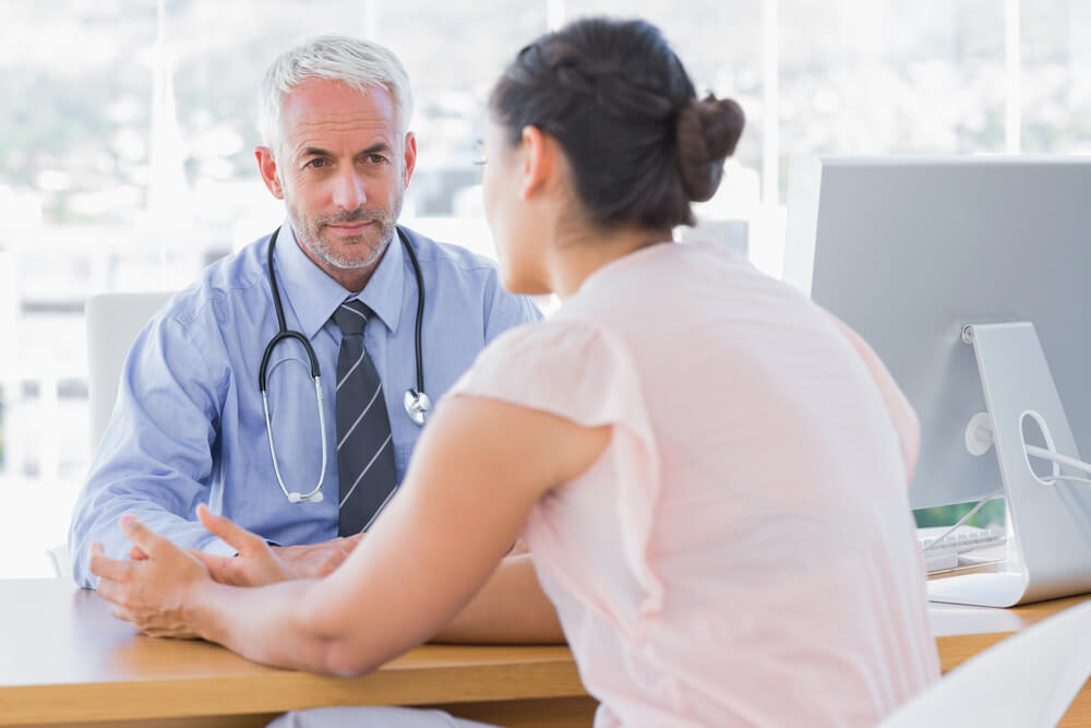 Patient Explaining Her Painful to Doctor in the Office