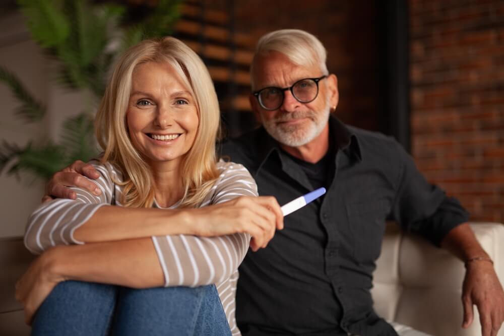 Happy Mature Husband and Wife With Pregnancy Test.
