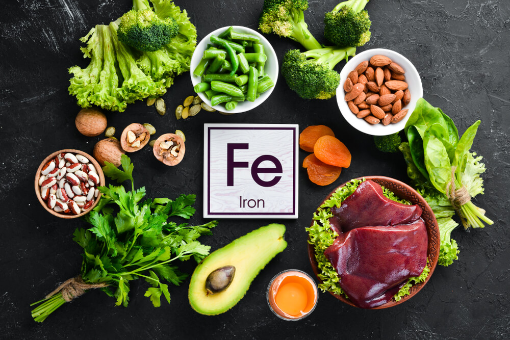 Food Containing Natural Iron. Fe: Liver, Avocado, Broccoli, Spinach, Parsley, Beans, Nuts, on a Black Stone Background