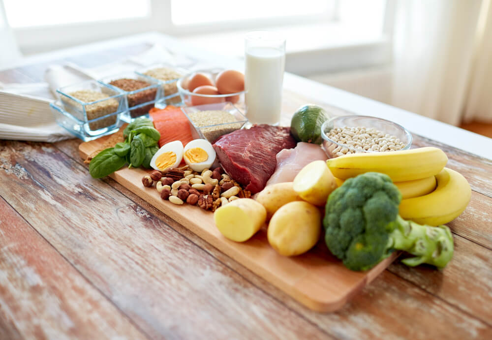 balanced diet, cooking, culinary and food concept - close up of vegetables, fruit and meat on wooden table