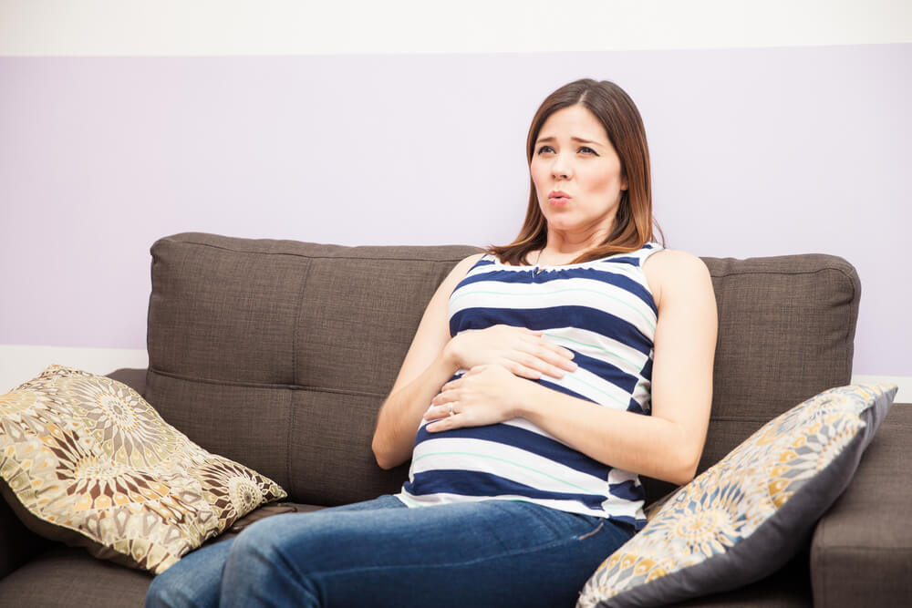 Portrait of a Young Pregnant Woman Focusing on Her Breathing While She Has Braxton Hicks Contractions