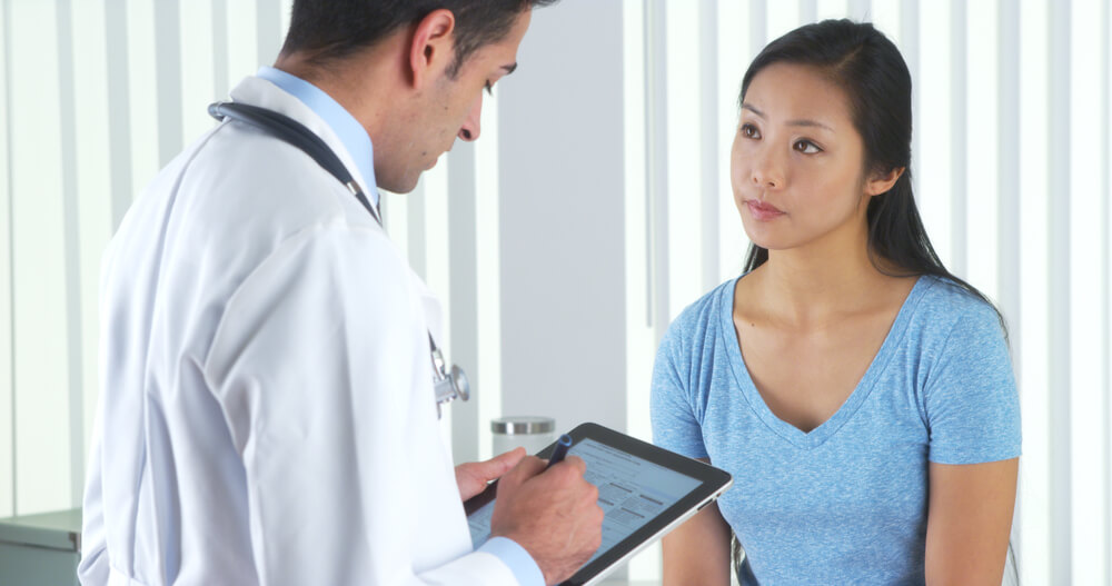 Hispanic Doctor Asking Asian Patient Questions