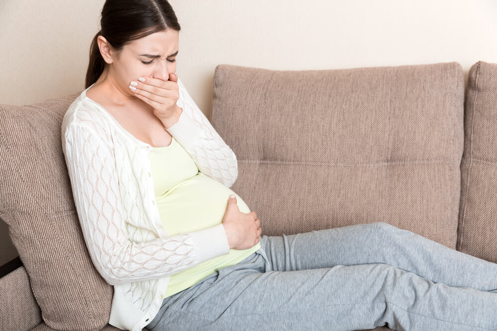 Pregnant Woman Having Nausea Feeling Bad in Sofa at the Home.