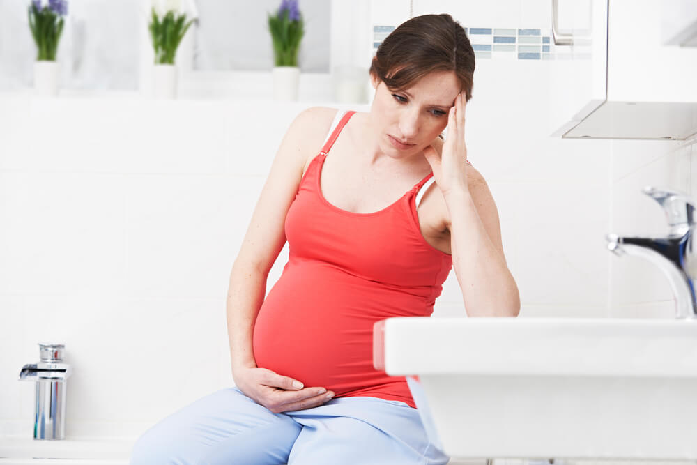 Pregnant Woman Suffering From Constipation in Bathroom