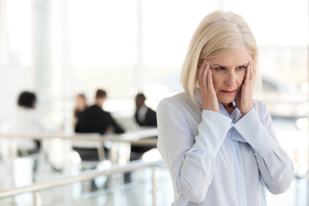 Stressed Fatigued Mature Businesswoman Touching Temples Suffer From Headache Migraine at Office Meeting