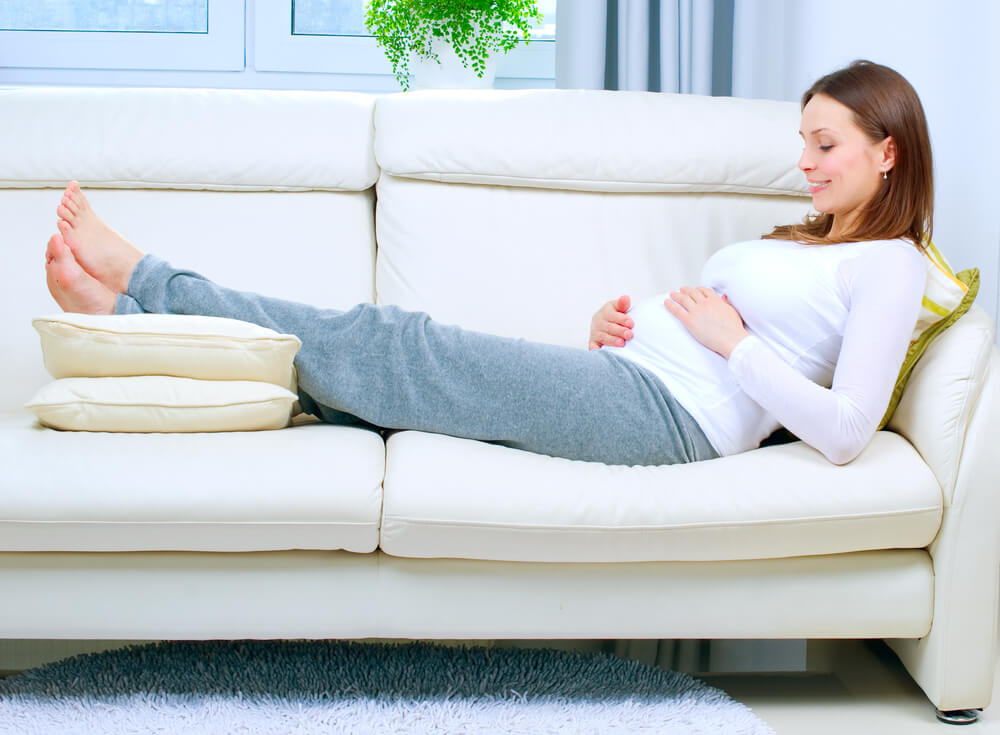 Pregnant woman resting on the sofa at home.