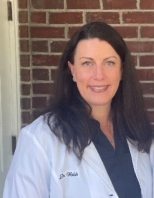Two female doctors standing together outside in front of their office