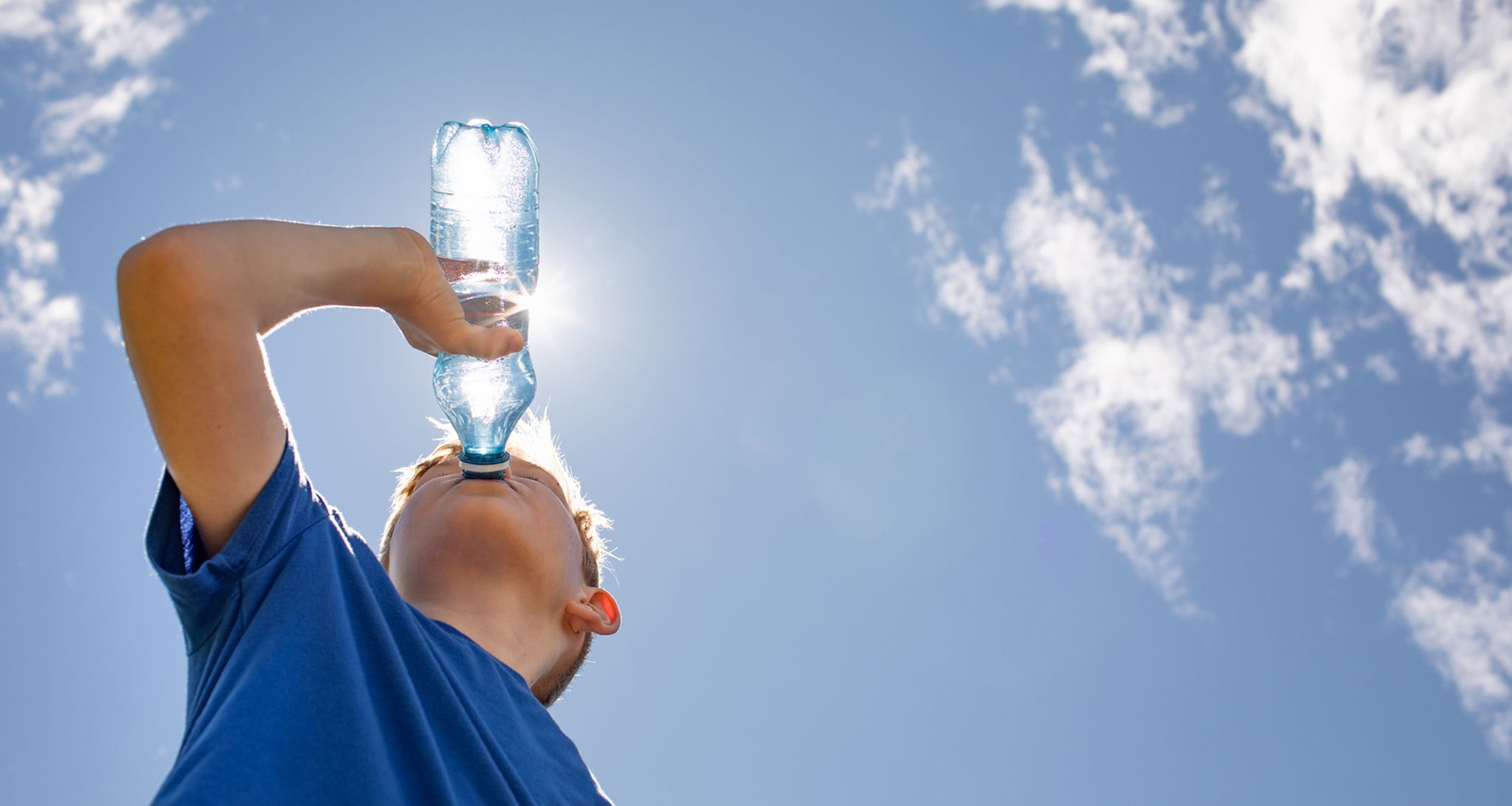 Boy replenishing fluids on a hot summer day.