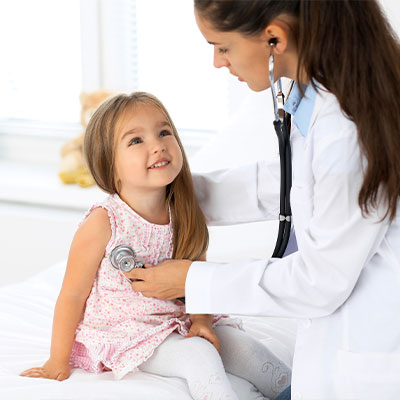 Female doctor examining a cute girl with a stethoscope