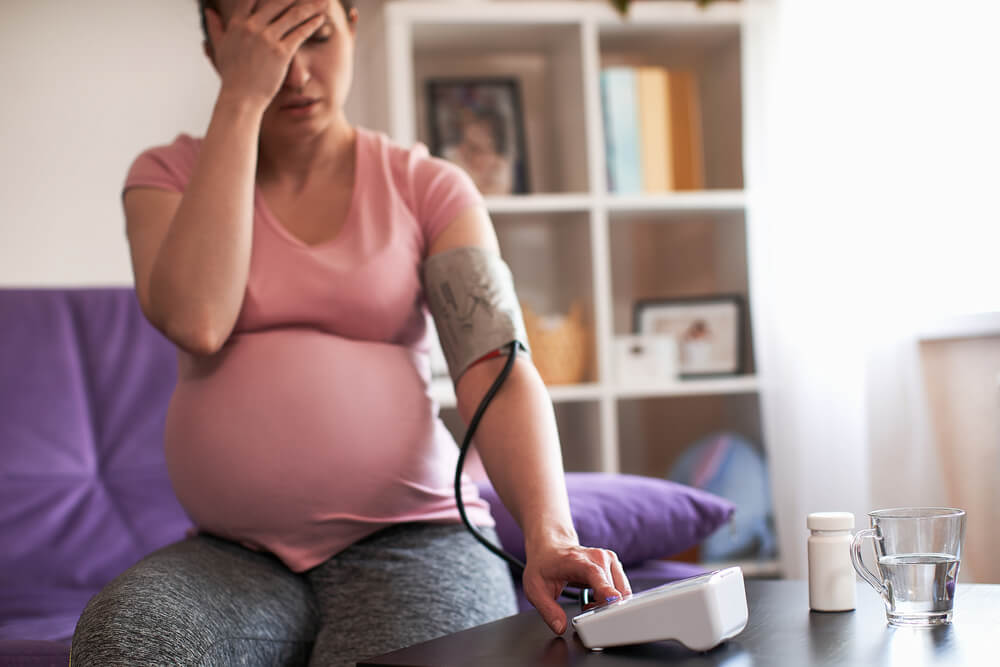 Pregnant woman measures blood pressure