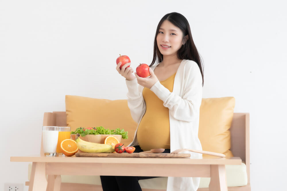 pregnant woman holding apples