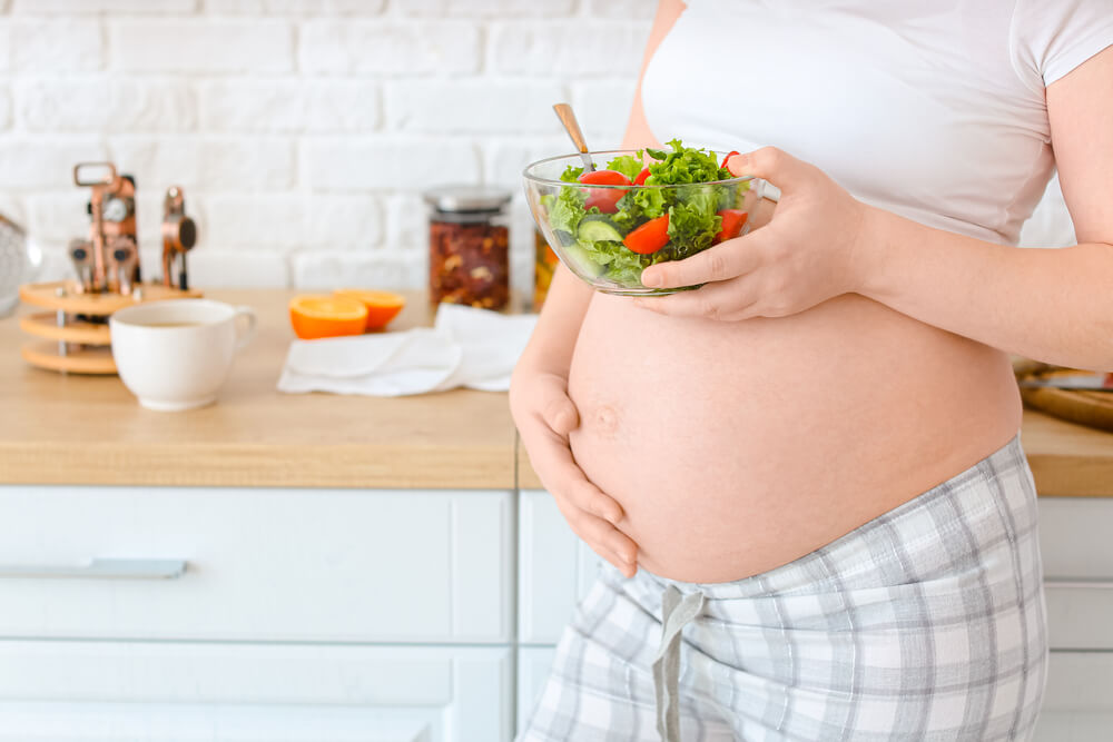 Pregnant Woman With Healthy Salad in Kitchen