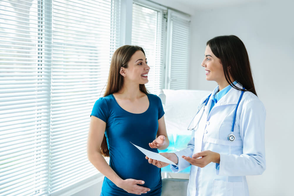 Female Gynecologist Working With Pregnant Woman in Clinic