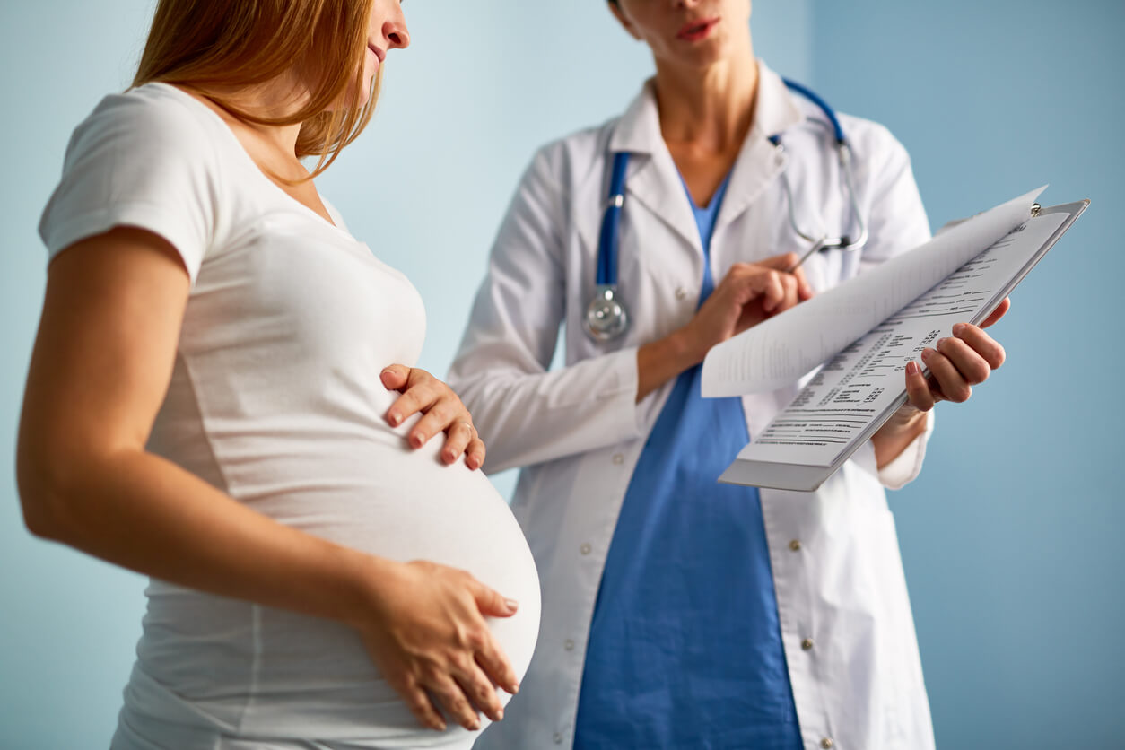 Pregnant Female Looking at Paper With Medical Prescriptions Held by Her Therapeutist