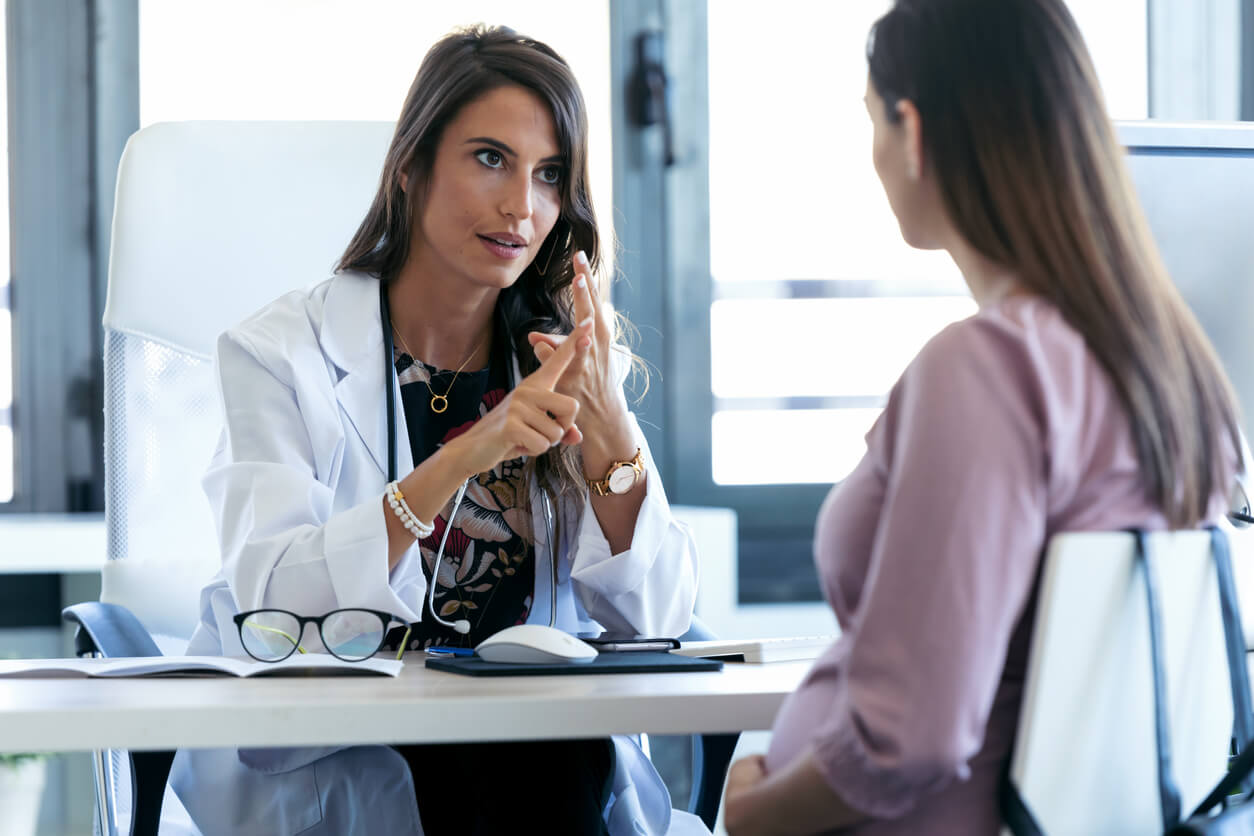 Shot of Serious Young Gynecologist Giving Guidelines to His Pregnant Patient in the Clinic.