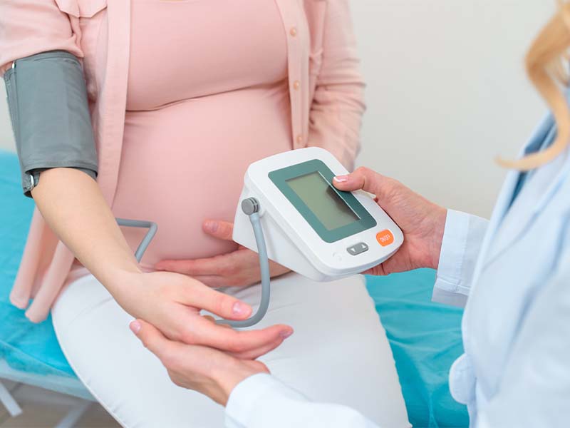 A woman getting her blood pressure taken by obstetrician