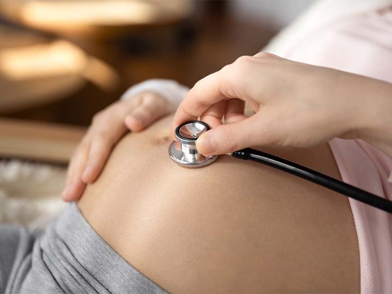 Obstetric 5 | Women's Care of Bradenton doctor listening to a pregnant belly