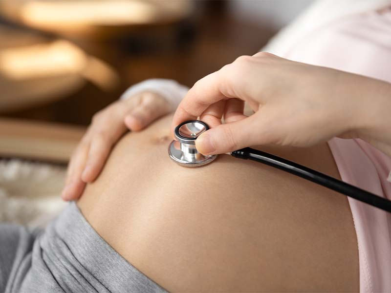 doctor listening to a pregnant belly