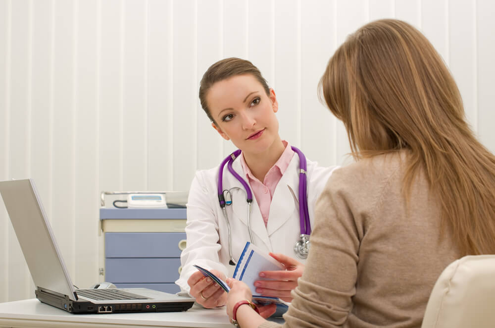 Doctor Advises Woman Patient and Writing Prescription