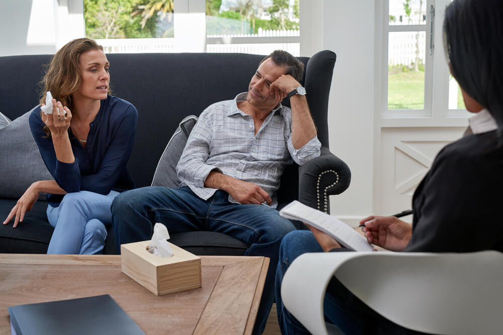 Mature Couple Seated on Couch, Woman Crying During Therapy Session
