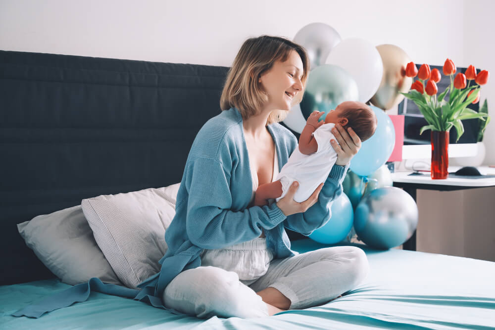 Mother Holds Her Newborn in Hands. Mom and Baby Together.